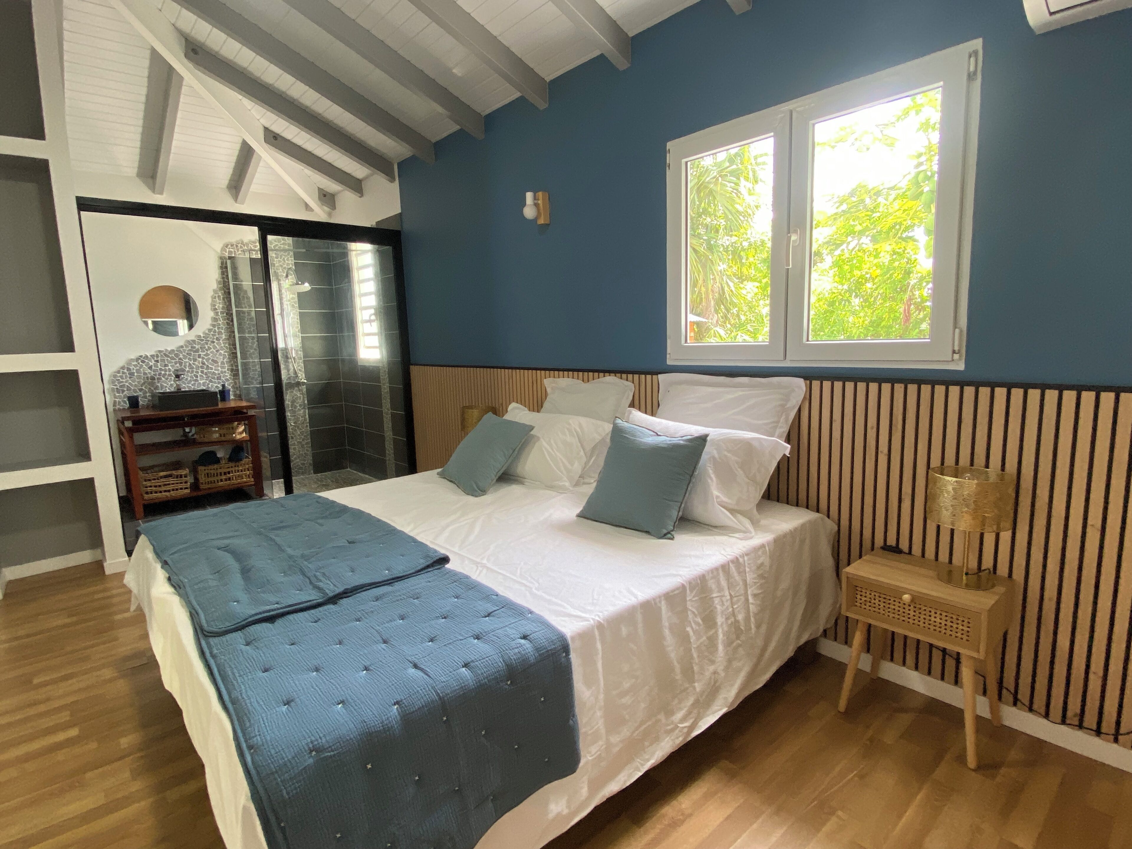 Une chambre à coucher avec un lit, une fenêtre, une table de chevet et une armoire.