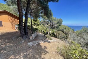 Un edificio con una escalera de piedra que lleva a una terraza con vistas a la costa.