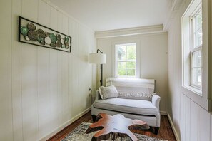 Ein gemütliches Wohnzimmer mit einem grauen Sofa, einem Holztisch und einem gerahmten Kunstwerk an der Wand.
