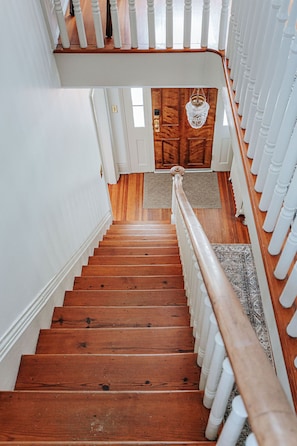 A wooden staircase with white balusters leading to a wooden door.