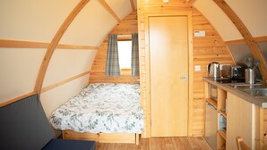 A cozy, single-room RV with a bed, kitchenette, and a window. - Rural Cosy Cabin With Beautiful Views Over Fife (Leven)