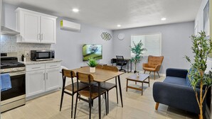 Ett kompakt bostadsutrymme med ett litet kök, matplats och sittgrupp.
