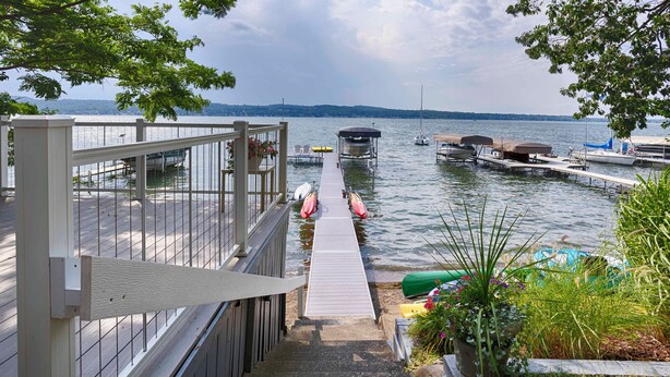 A dock leading to a body of water with boats and a covered seating area. - Lake Escape: The Definition of Lakefront Luxury (Canandaigua)