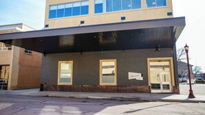 En modern byggnad med ett platt tak, stora fönster och en överbyggd entré.