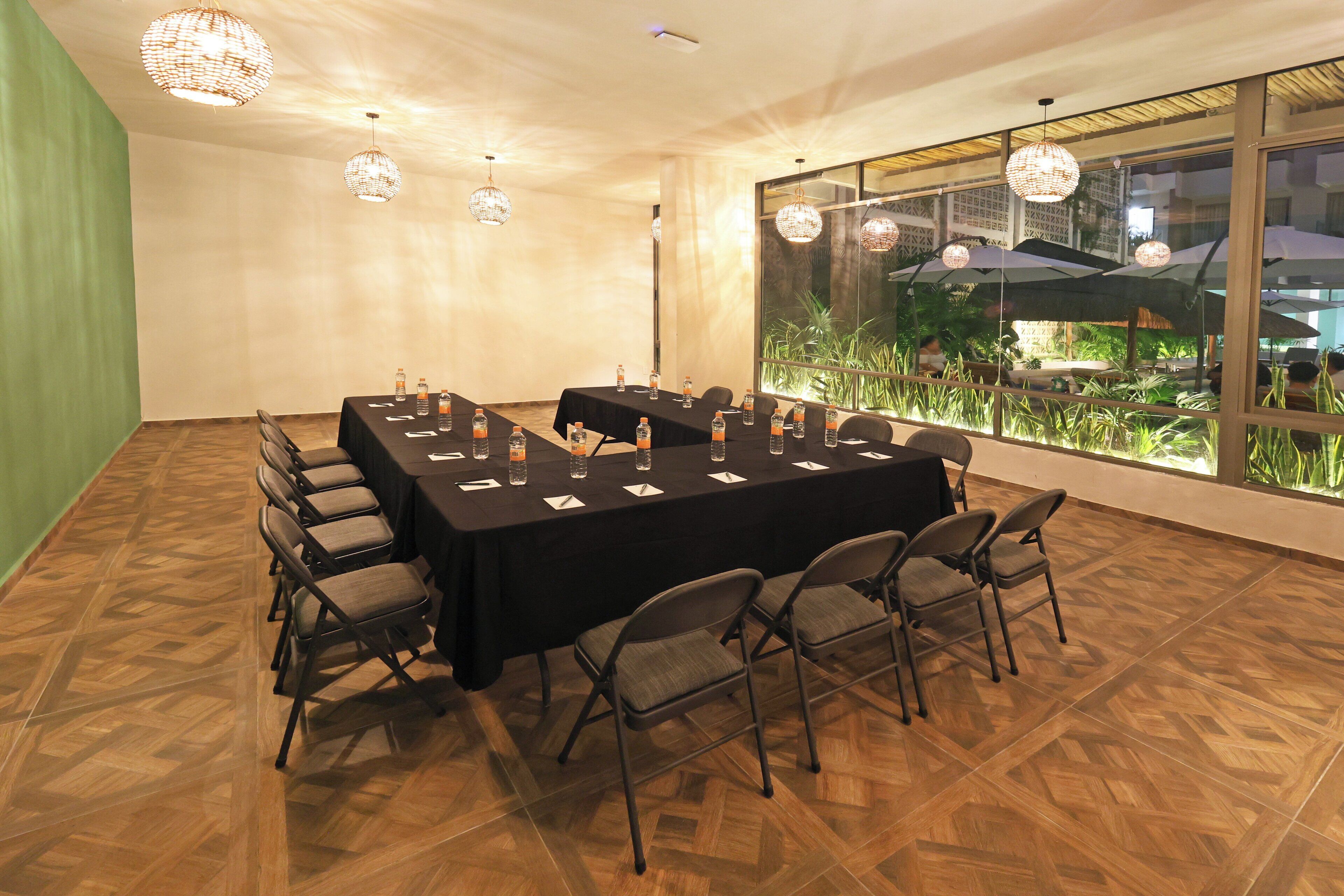 A conference room with a long table, chairs, and large windows with umbrellas.