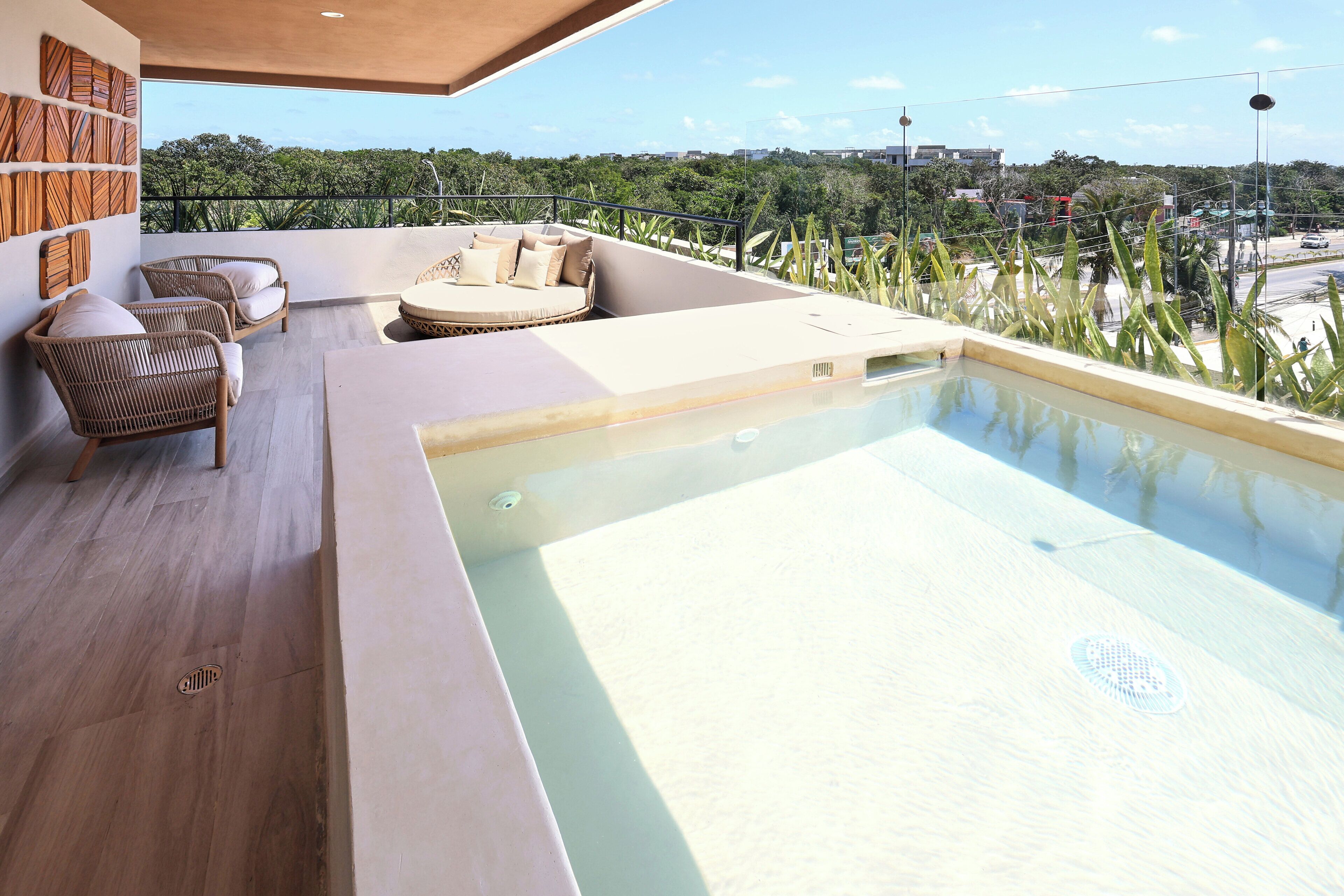 A rooftop pool area with seating and a view of the city.