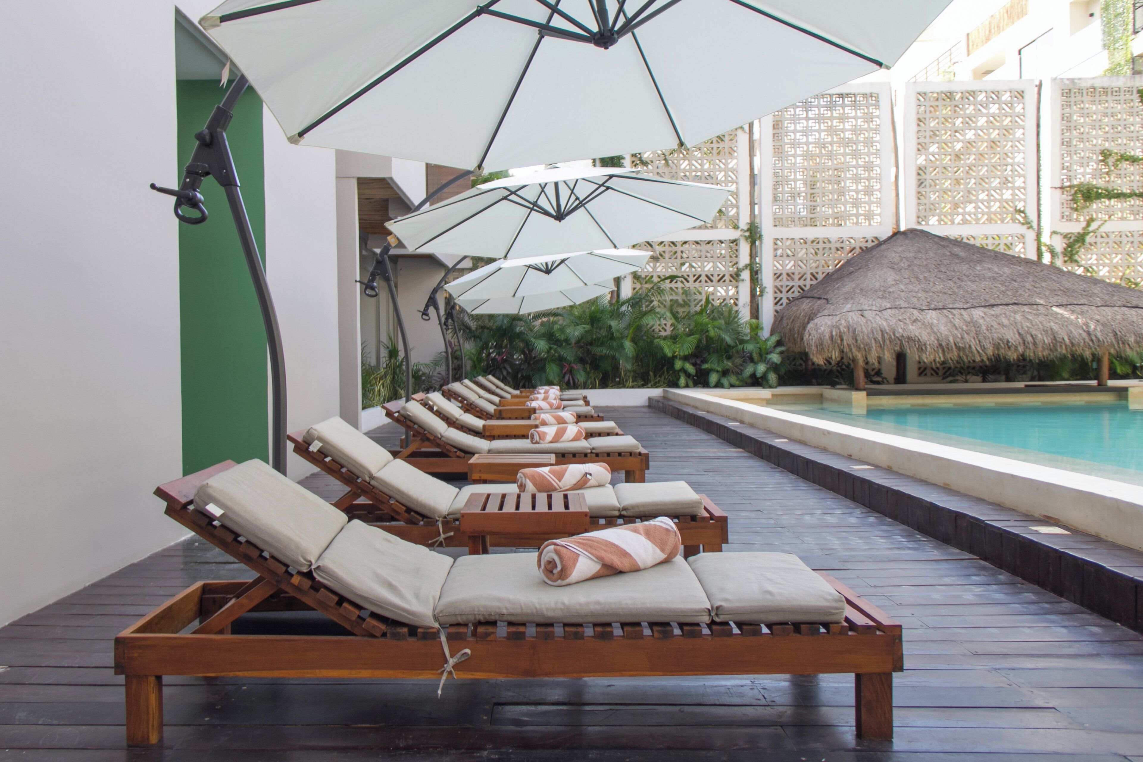 Un espace aménagé au bord de la piscine, avec des chaises longues et des parasols.