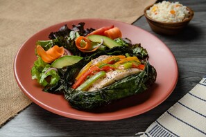 A plate with a stuffed pepper, salad, and rice.