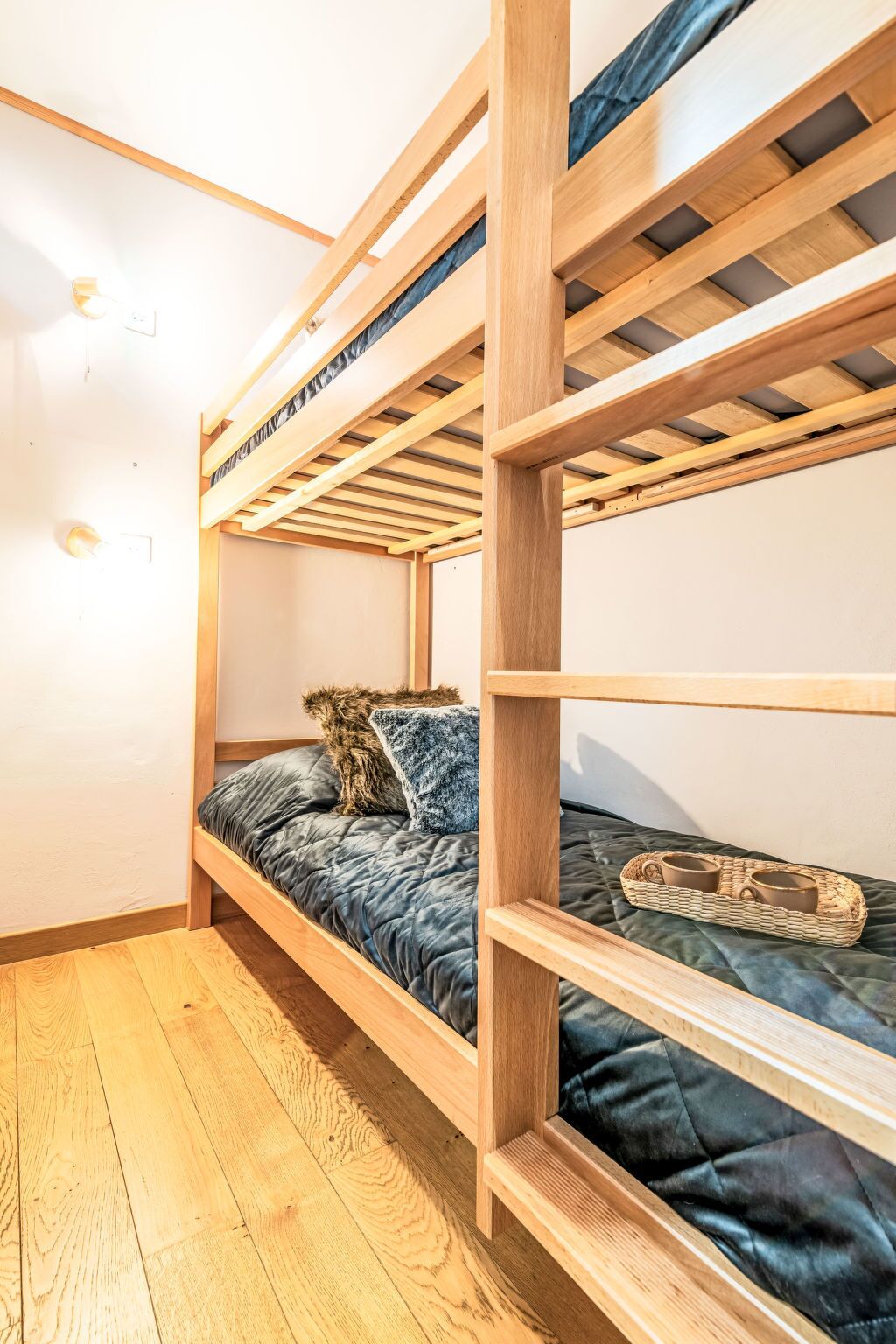 A bunk bed with a wooden frame and a quilted mattress.