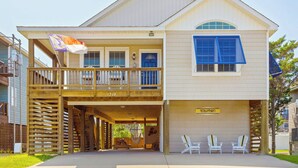 A two-story house with a balcony, a sign reading "Rogers Bamboo," and a flag. - 5178 Sea-Cryst * 3 Min Walk to Beach (Kill Devil Hills)