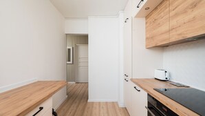 A modern kitchen with wooden countertops, a built-in oven, and a toaster.