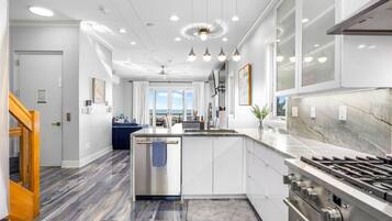 A modern kitchen with a central island, stainless steel appliances, and pendant lighting.