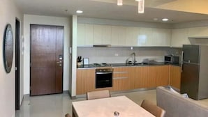 A modern kitchen with wooden cabinets, a built-in oven, and a refrigerator.