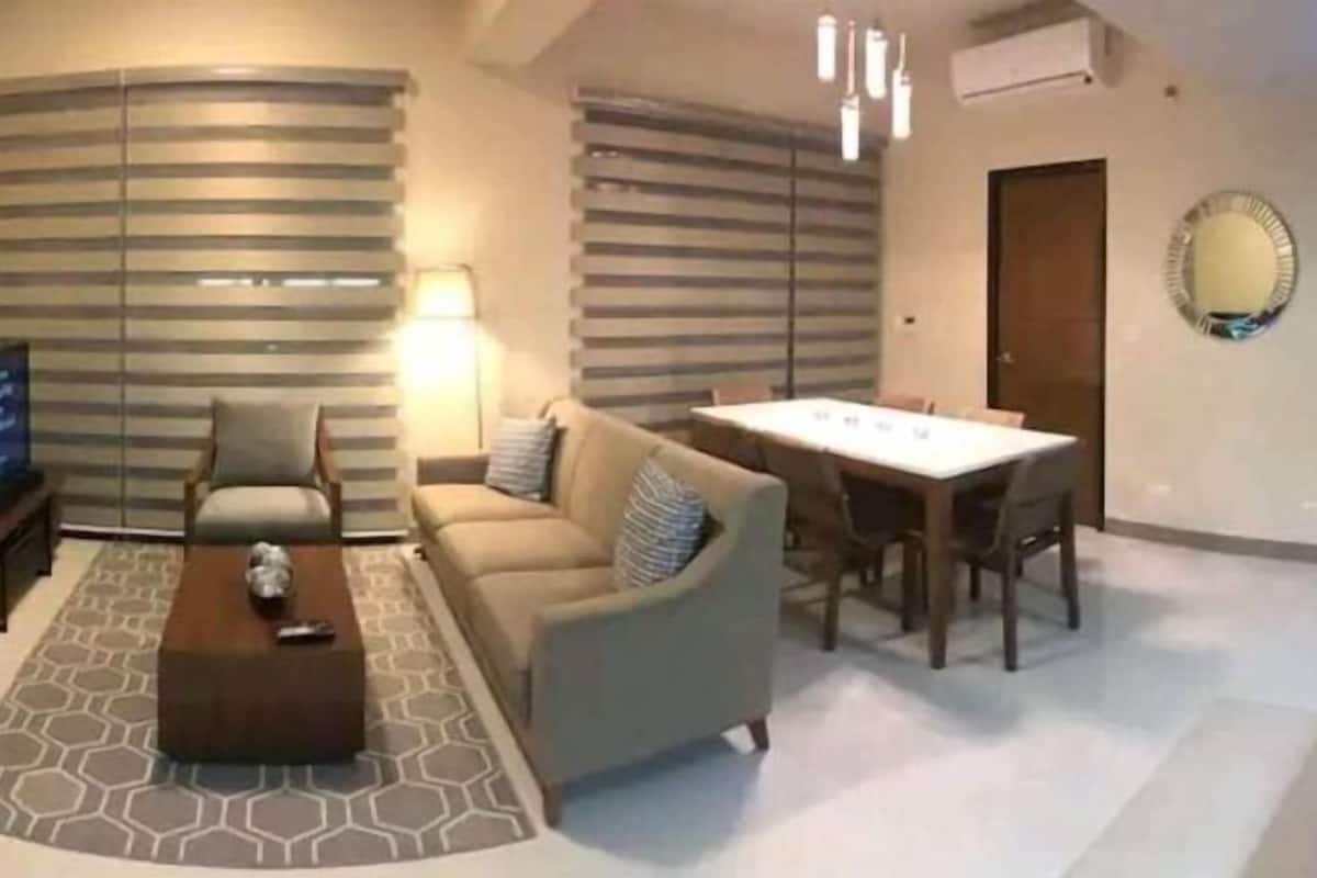 A modern living room with a sofa, coffee table, and dining table.