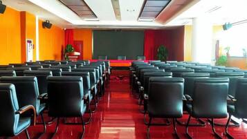 A conference room with rows of chairs facing a stage.