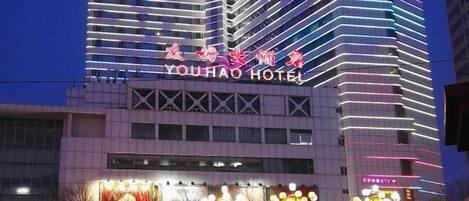Standing tall in the city, the Youhao Hotel showcases a sleek, modern design with a grid-like facade.
