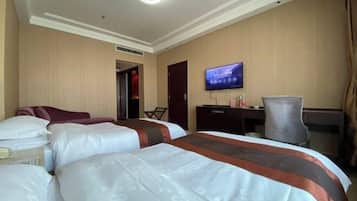 A hotel room with two beds, a television, a desk, and a chair.
