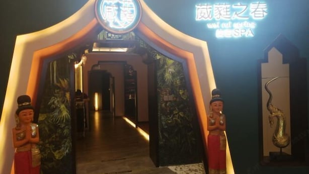 A hotel entrance with a neon sign, two statues, and a snake sculpture. - Friendly Hotel (Meimei Shopping Center Autonomous Region Museum Branch) (Urumqi)