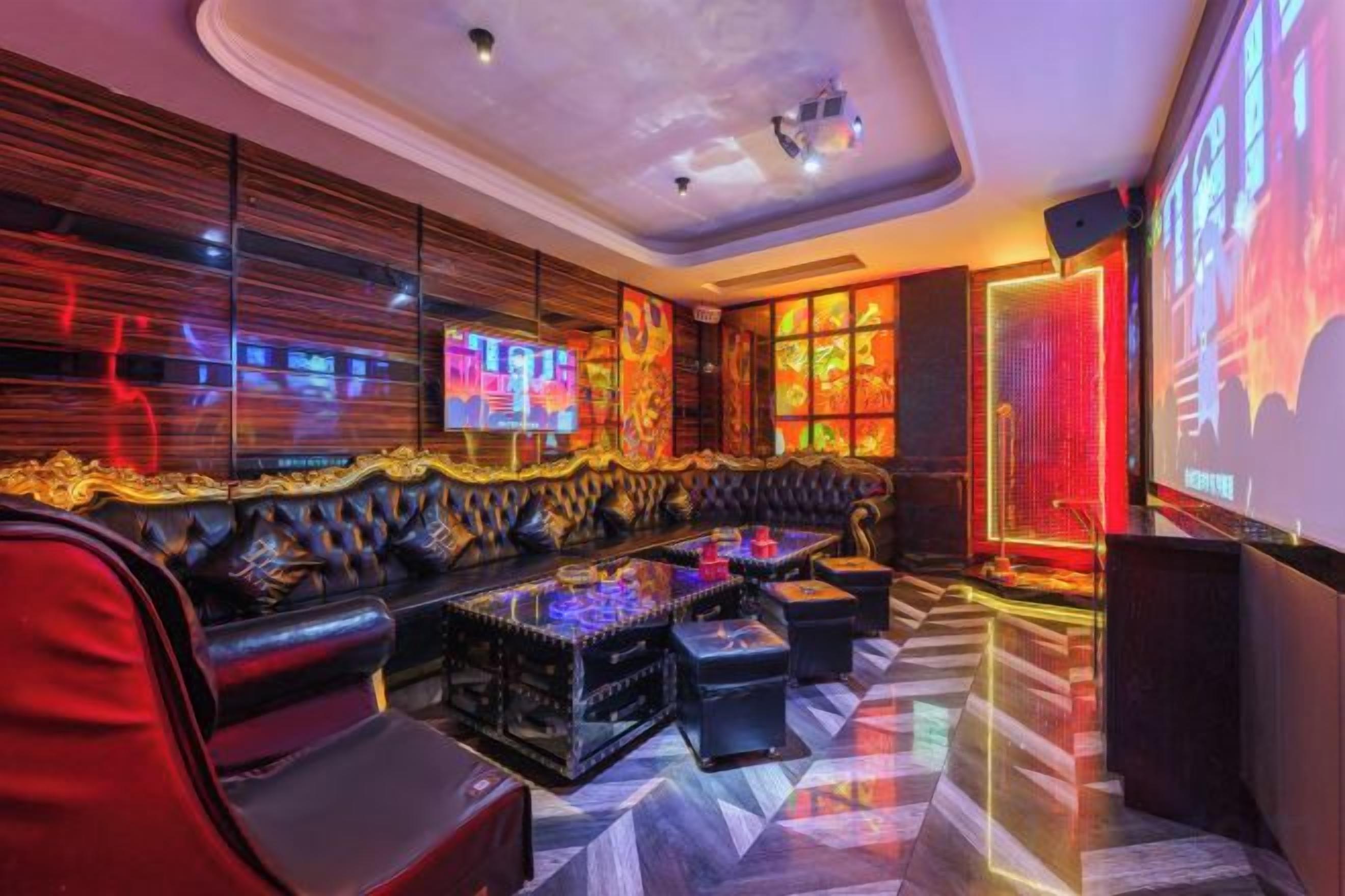 A modern lounge area with a leather sofa, a coffee table, and a flat-screen TV.