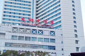 A hotel building with a modern design, featuring a prominent sign with Chinese characters and the name 'YouHao Hotel' in English. - Friendly Hotel (Meimei Shopping Center Autonomous Region Museum Branch) (Urumqi)