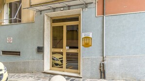 Un immeuble avec une porte numérotée, une entrée de garage et un panneau indiquant qu’il s’agit d’un immeuble en copropriété.