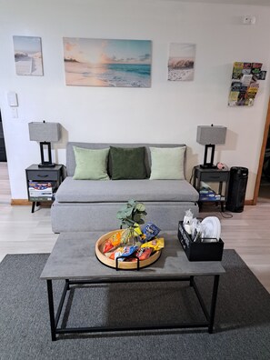 Relax in this stylish living room with a sofa, coffee table, and side tables, each with a lamp and drawer.
