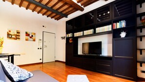 Una sala de estar moderna con un sofá, un televisor y una estantería.