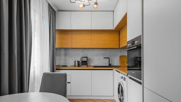 A modern kitchen with a washing machine, a coffee maker, and a built-in oven. - Lozenets apartment (Sofia)