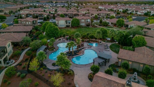 Zona residencial con una gran piscina rodeada de casas y vegetación.