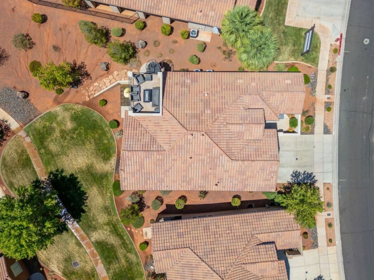Vista aérea de una zona residencial con varias casas, cada una con techo de tejas y rodeada de jardines ajardinados.