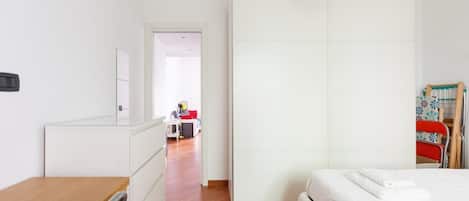Un dormitorio con cama, cómoda, armario y escritorio.