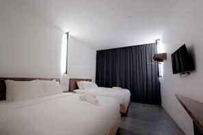 A hotel room with two beds, a flat-screen TV mounted on the wall, and a large window with curtains. - T Hotel Jalan Sultanah (Alor Setar)