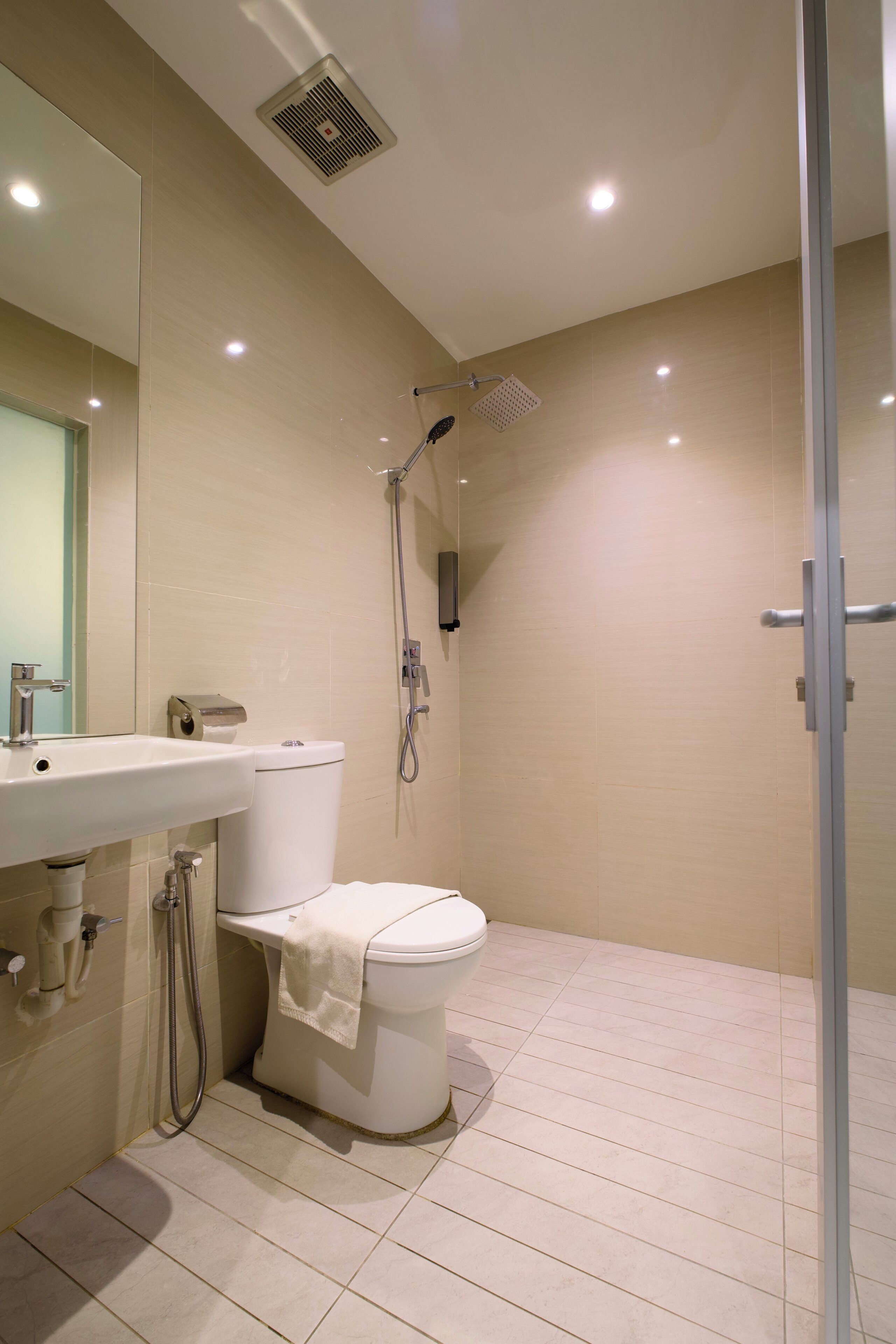 Un baño moderno con inodoro, lavamanos y ducha.