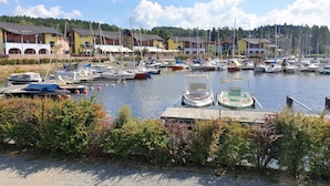 A marina with boats docked, surrounded by buildings with balconies and a clear sky. - Residence Lipno by Interhome (Lipno nad Vltavou)