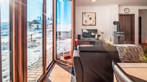 A modern living room with a large sliding glass door leading to a snowy outdoor area. - Residence Lipno by Interhome (Lipno nad Vltavou)