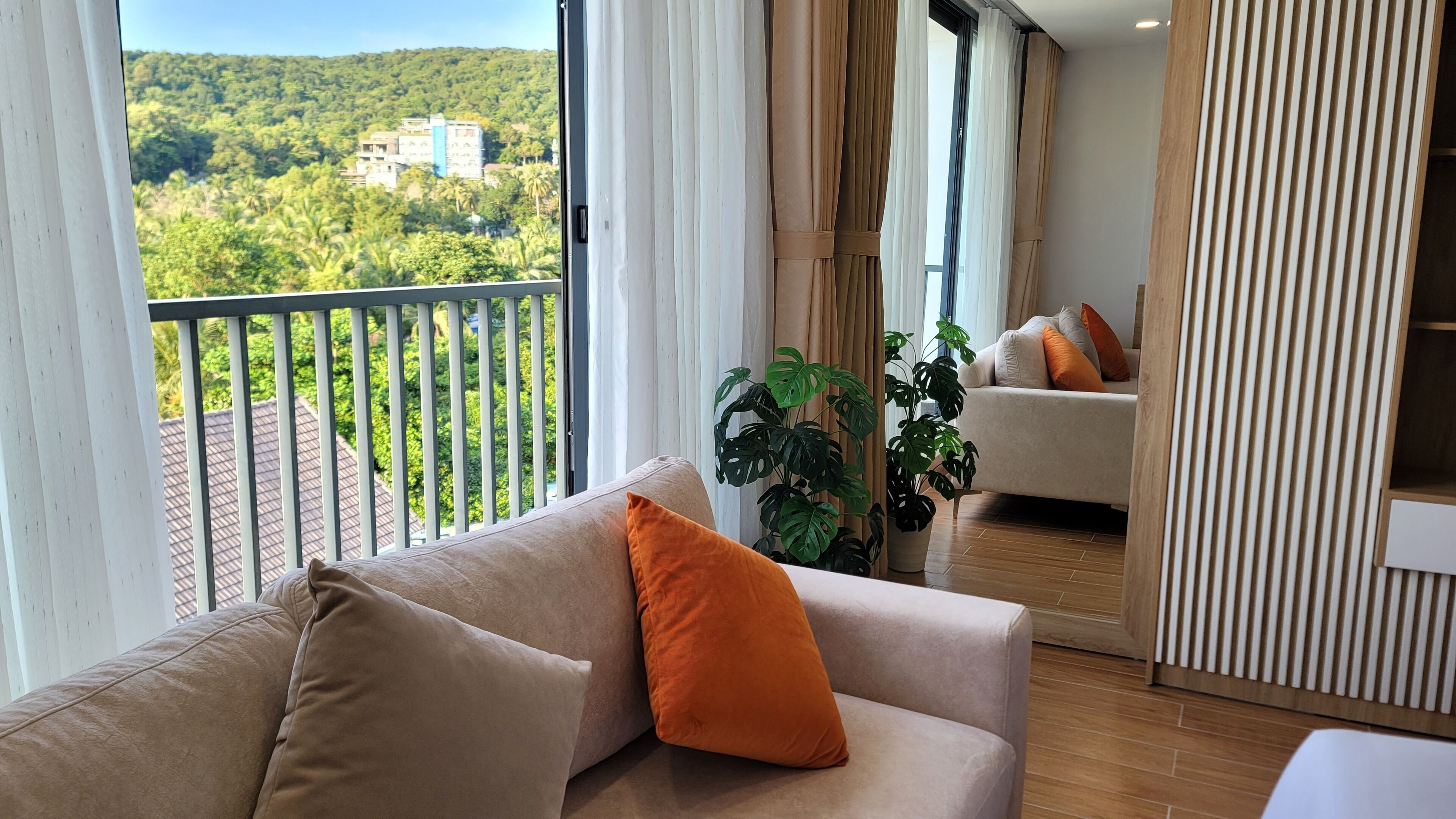A balcony with a view of a green landscape and a building.