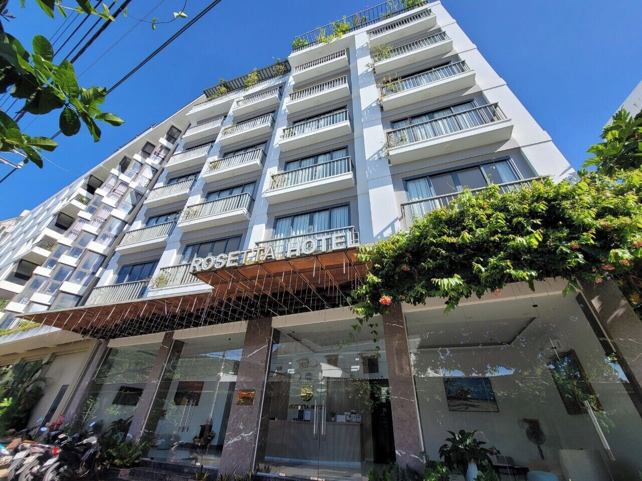 Ein mehrstöckiges Hotel mit moderner Fassade, Balkonen und einem überdachten Eingangsbereich.