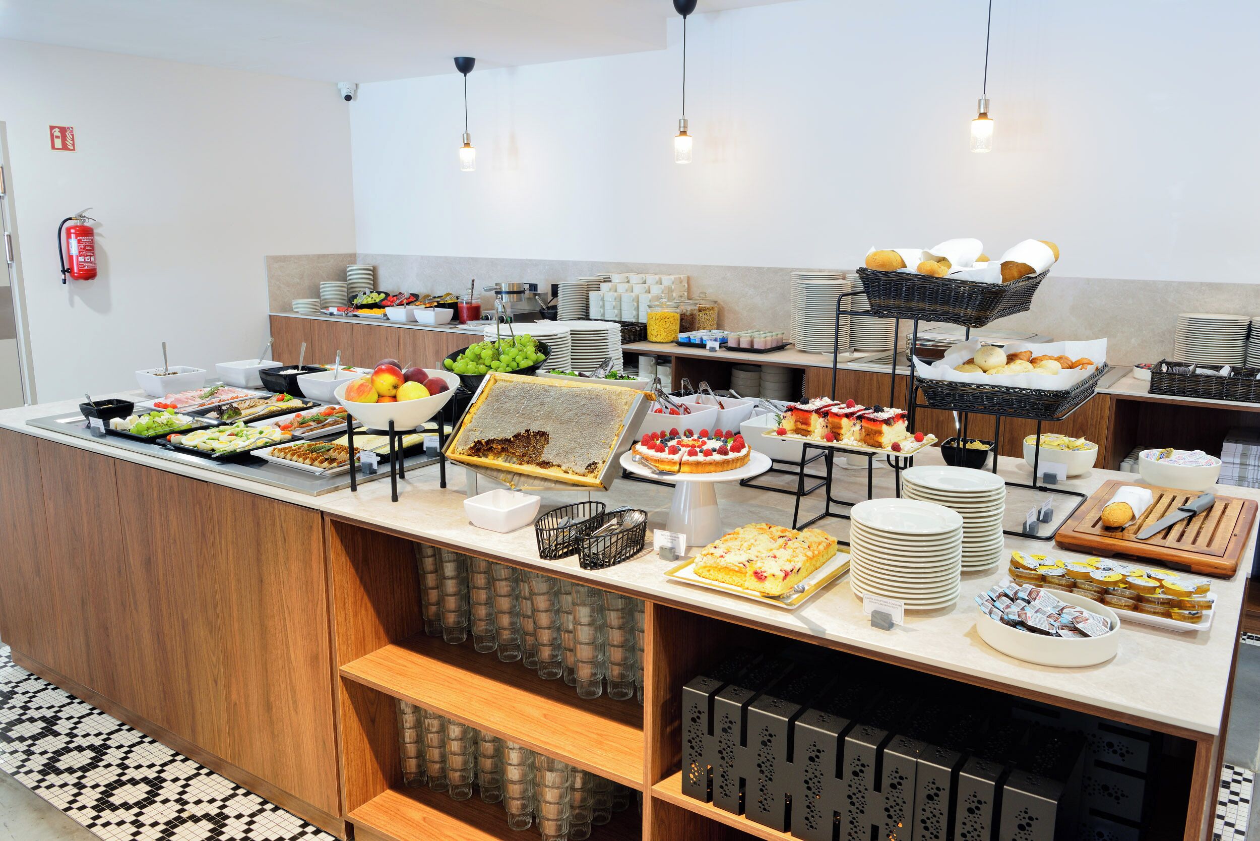 A buffet with various food items and beverages, including fruits, pastries, and salads.