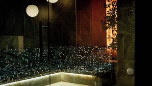 An indoor venue with tiered seating, a stage, and a decorative wall.