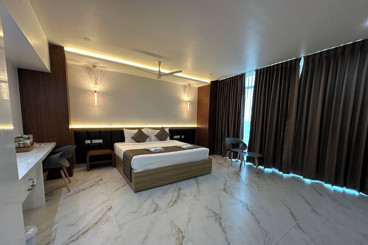 Une chambre d’hôtel moderne, dotée d’un grand lit, d’un bureau et d’une chaise.