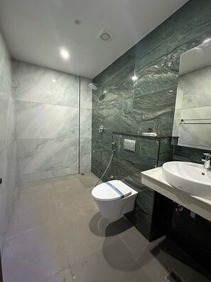 Ein modernes Badezimmer mit Toilette, Waschbecken und Dusche.