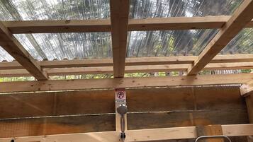 Une structure en bois au plafond, avec un chauffe-eau et un panneau d’avertissement.