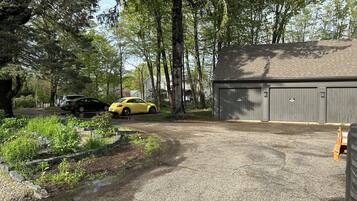 Ein Schotterweg führt zu einer Garage, in der ein Auto geparkt ist.