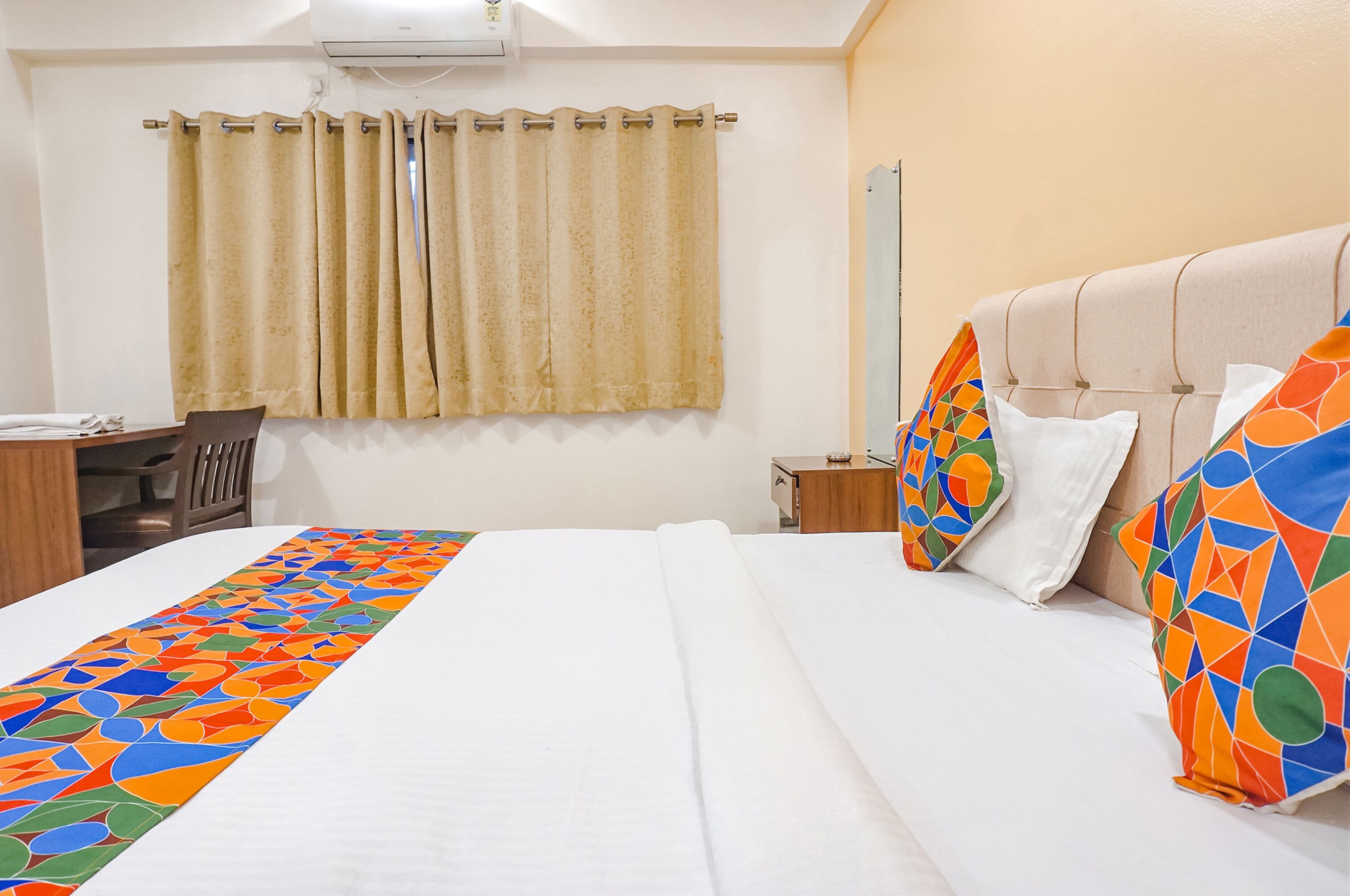 A hotel room with a bed, a desk, and a chair.