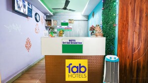 Ein Empfangsbereich mit einem Schild für 'fab hotels' und 'Sri Sai Grand Inn'.