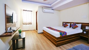 Ein Schlafzimmer mit einem Bett, einem Schreibtisch, einem Stuhl, einem Deckenventilator und einer Klimaanlage.