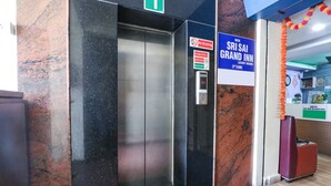Ein Aufzug mit digitaler Anzeige, einem Rauchverbotsschild und einem Schild für das Sri Sai Grand Inn, 3. Etage.