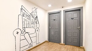 Un couloir avec deux portes grises, l’une portant le numéro 105 et l’autre le numéro 104.