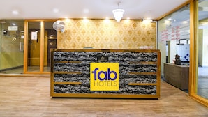 Un comptoir d’accueil au design en marbre, orné du logo « fab hotels ».