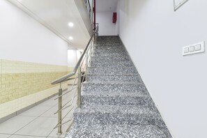 A staircase with a metal handrail and tiled walls. - Fabexpress Perfect (Samba)